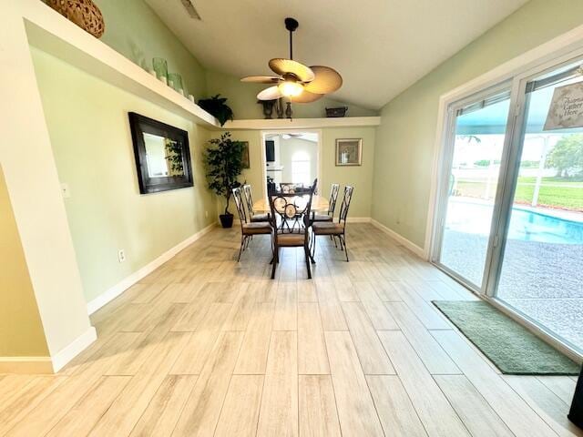 dining room with light wood-type flooring, ceiling fan, and lofted ceiling