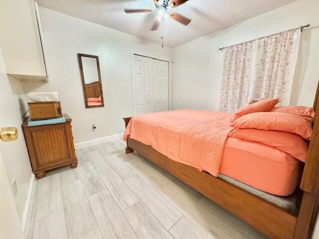 bedroom featuring ceiling fan, light hardwood / wood-style floors, a textured ceiling, and a closet