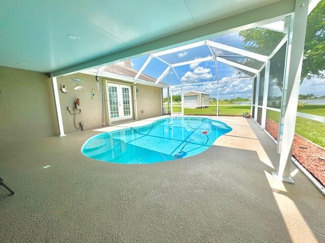 view of swimming pool featuring glass enclosure, a patio area, and french doors