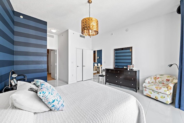 bedroom featuring a textured ceiling and an inviting chandelier