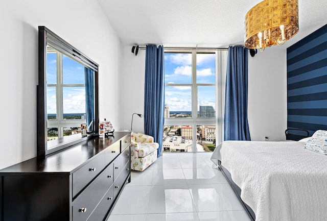 bedroom with light tile patterned floors, a textured ceiling, and an inviting chandelier