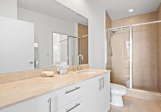 bathroom with tile patterned flooring, vanity, toilet, and an enclosed shower