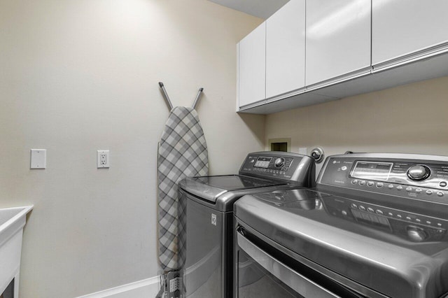 washroom featuring cabinets and washing machine and clothes dryer