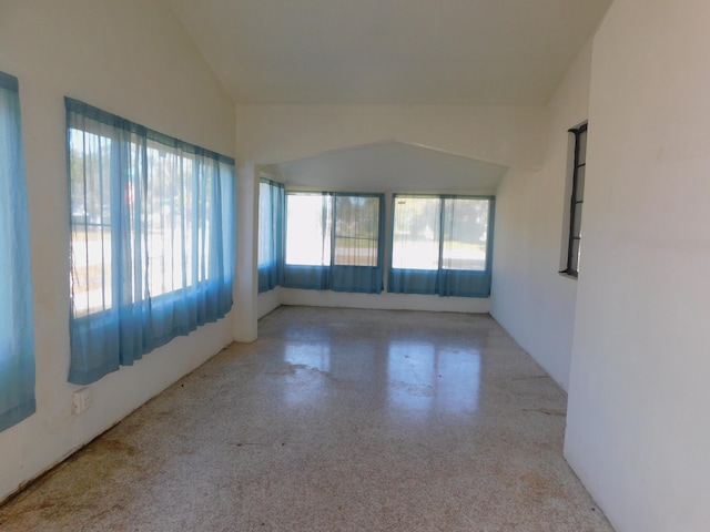 unfurnished room with vaulted ceiling