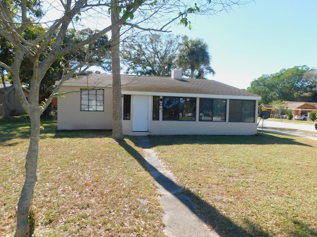 view of front of house with a sunroom and a front yard