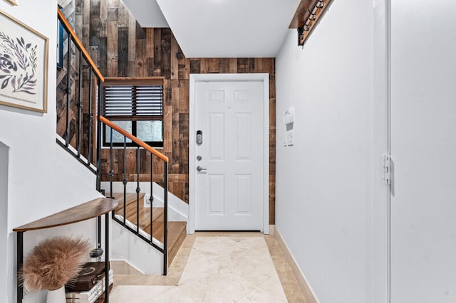 foyer featuring wooden walls