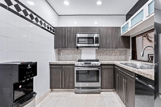 kitchen featuring dark brown cabinets, light tile patterned flooring, sink, and stainless steel appliances