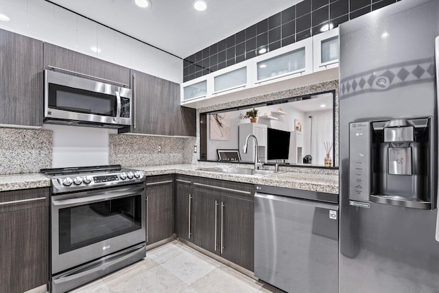 kitchen with decorative backsplash, dark brown cabinetry, sink, and appliances with stainless steel finishes