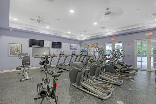 workout area featuring a raised ceiling, ceiling fan, and french doors