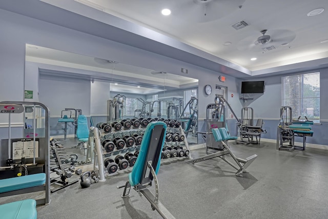 gym featuring ceiling fan and a raised ceiling