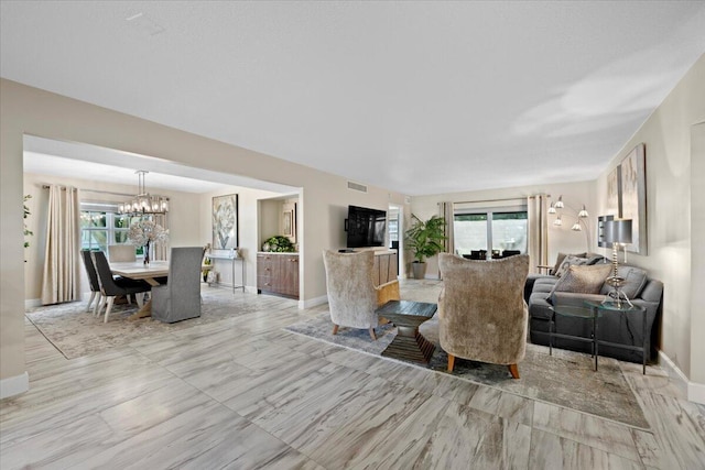 living room featuring a chandelier, visible vents, and baseboards