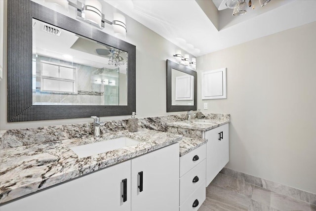 bathroom with baseboards, walk in shower, and vanity