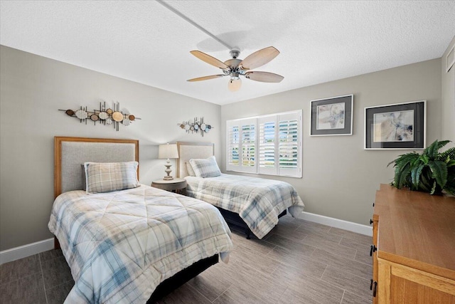 bedroom featuring baseboards, a textured ceiling, and a ceiling fan