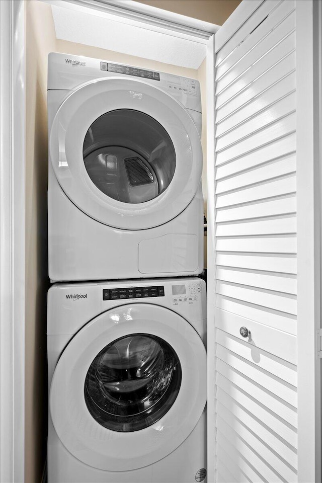 laundry area featuring stacked washer and clothes dryer and laundry area