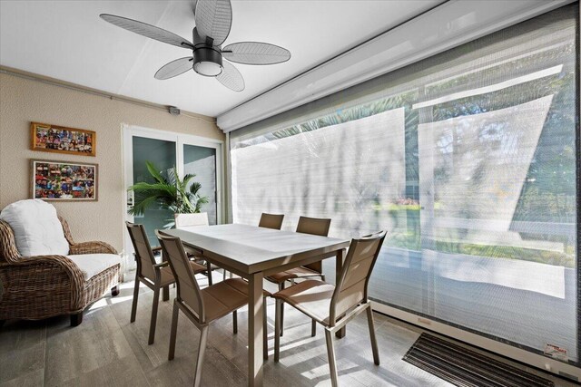 dining space with a baseboard heating unit, wood finished floors, and ceiling fan