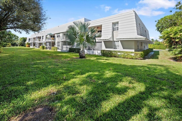 rear view of property with a lawn and stucco siding