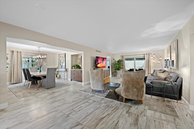 living area with visible vents, baseboards, and a chandelier