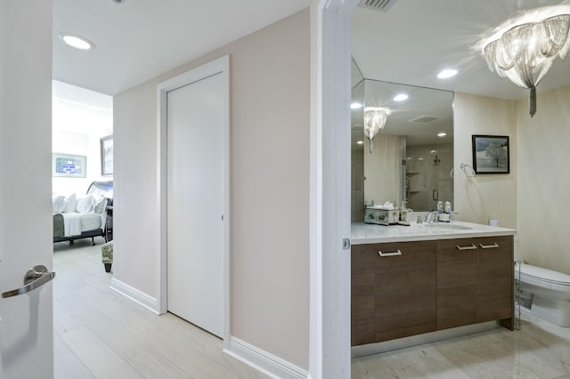 bathroom featuring vanity, toilet, and a shower with shower door