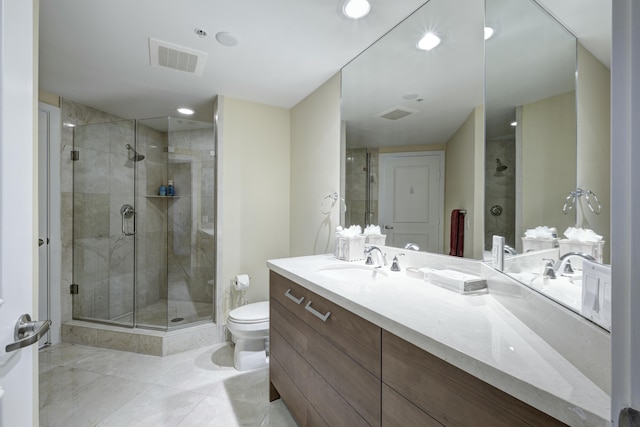 bathroom featuring vanity, toilet, and a shower with shower door