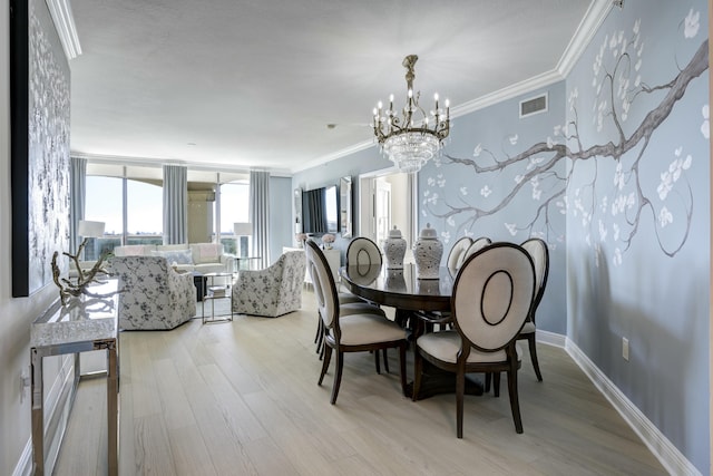 dining area featuring ornamental molding, a chandelier, and light wood-type flooring