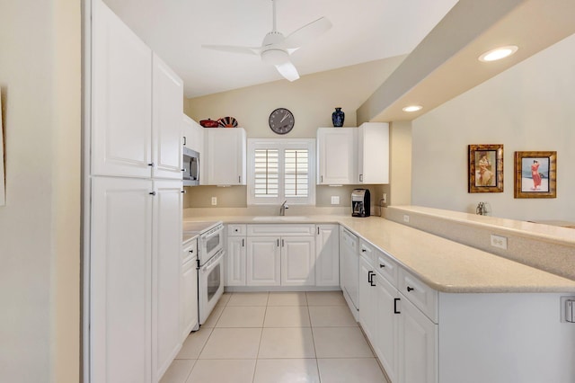 kitchen with white appliances, sink, vaulted ceiling, ceiling fan, and white cabinetry