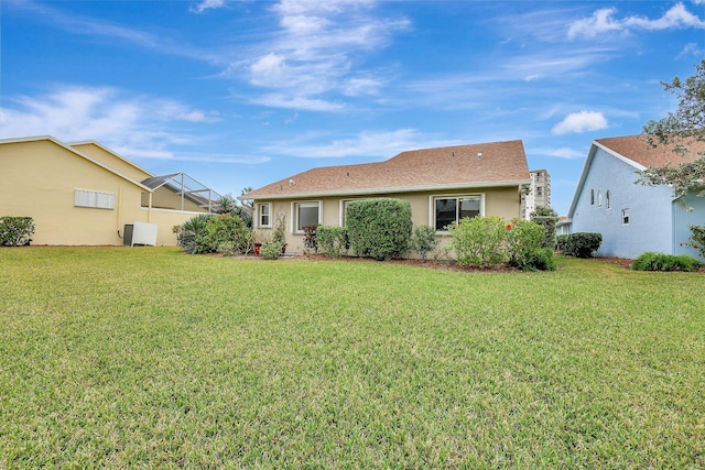 back of house with a lanai and a yard