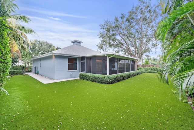 back of property with a sunroom and a yard