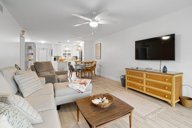 living room featuring light hardwood / wood-style floors and ceiling fan