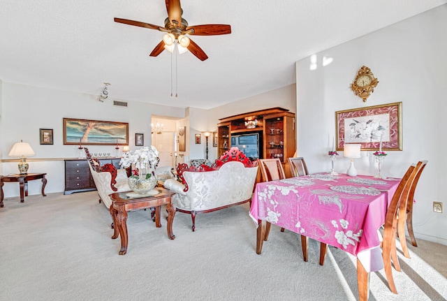 dining space with ceiling fan and light carpet