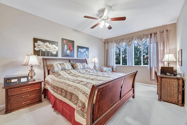 carpeted bedroom with ceiling fan and a textured ceiling