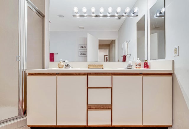 bathroom with vanity and a shower with door