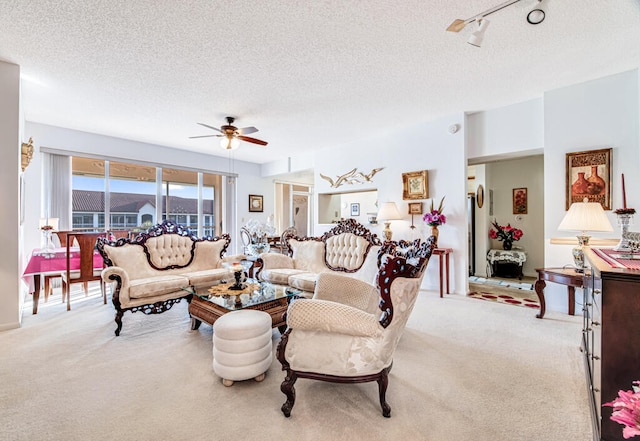 living room with light carpet, ceiling fan, a textured ceiling, and rail lighting