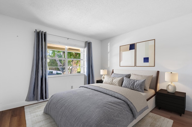 bedroom with wood-type flooring and a textured ceiling