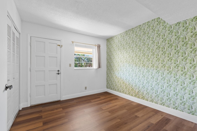 entrance foyer with a textured ceiling and dark hardwood / wood-style flooring