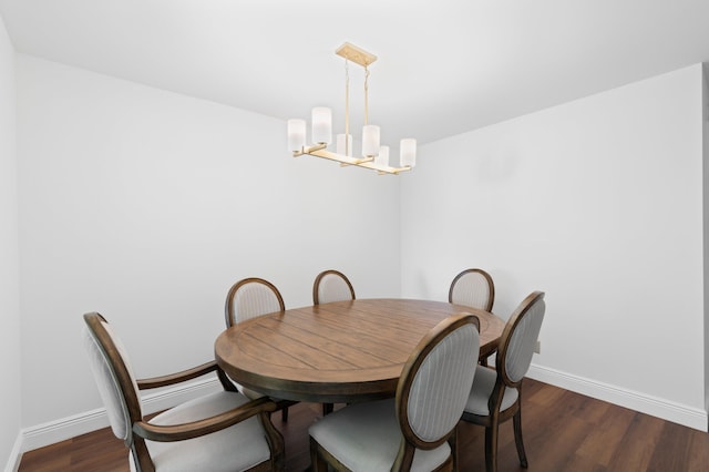 dining area featuring dark hardwood / wood-style flooring and an inviting chandelier