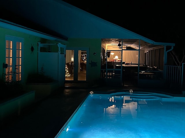 pool at twilight with a patio area and french doors