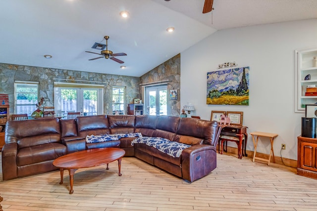 living room with french doors, light hardwood / wood-style floors, and vaulted ceiling