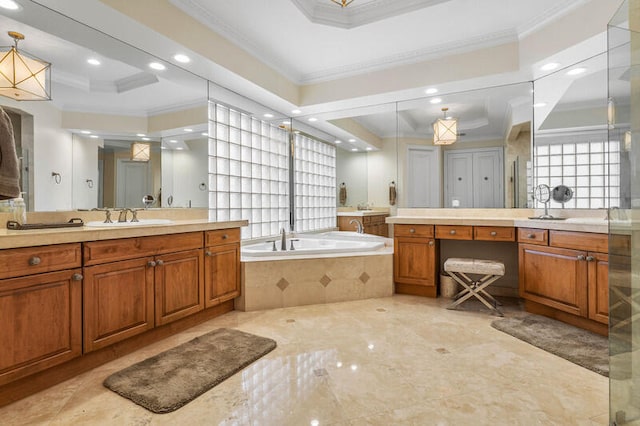 bathroom with a raised ceiling, tiled bath, crown molding, and vanity