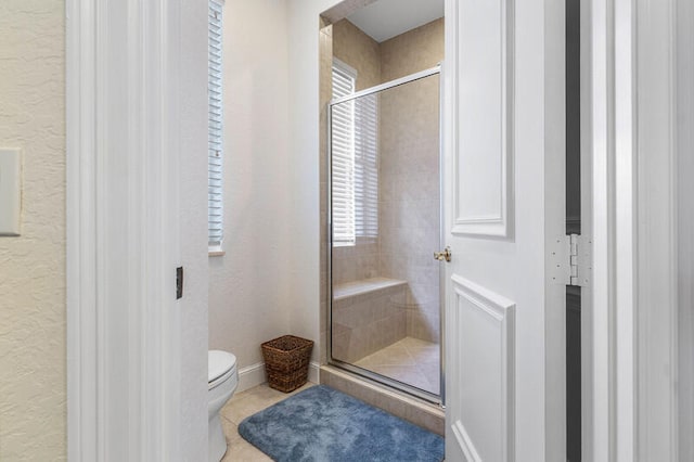 bathroom with toilet and a shower with door