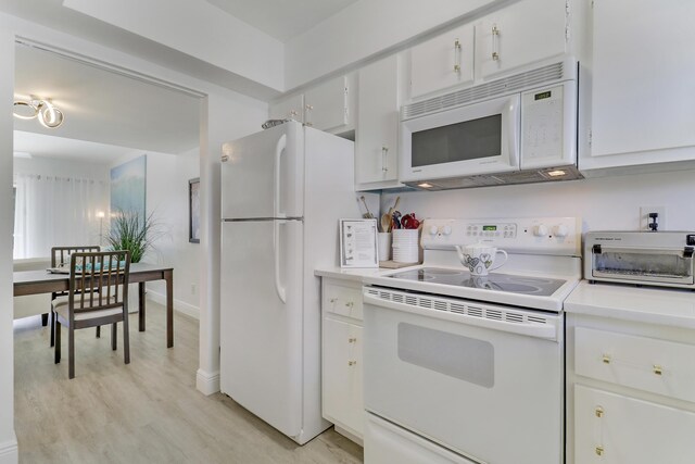 kitchen with white cabinetry, dark hardwood / wood-style floors, and white appliances