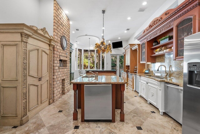 kitchen with stainless steel appliances, sink, a center island with sink, hanging light fixtures, and a breakfast bar area