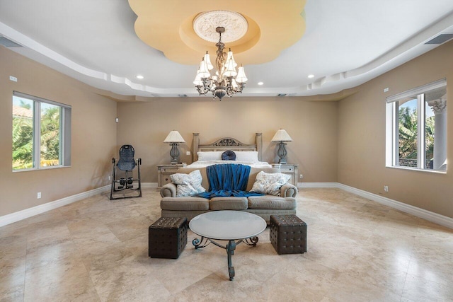 bedroom featuring an inviting chandelier and a raised ceiling