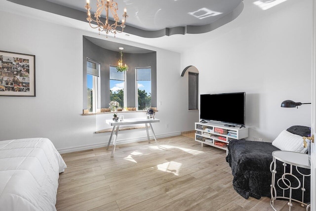 bedroom with a chandelier and light wood-type flooring