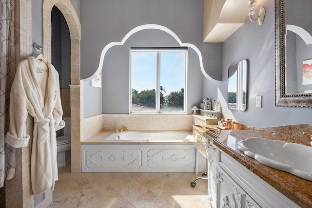 bathroom with vanity, toilet, and a tub