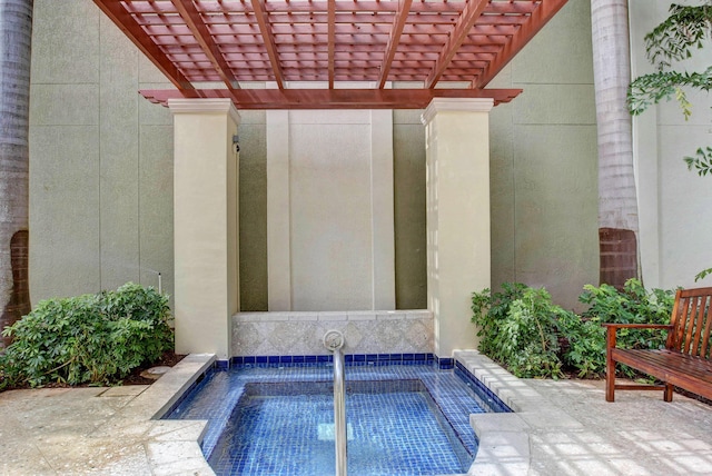 view of swimming pool featuring a pergola and an in ground hot tub