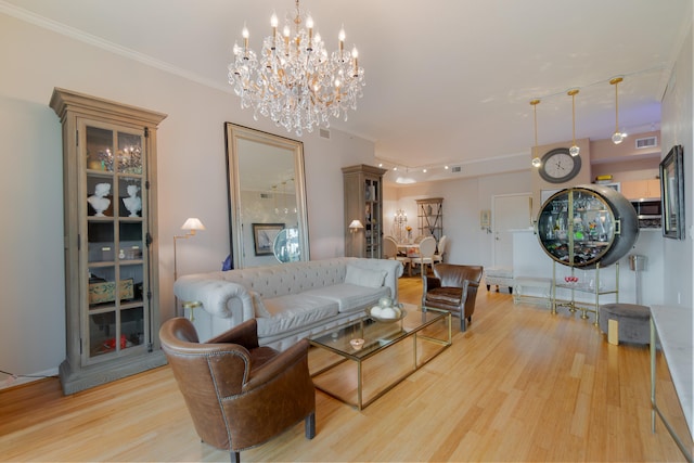 living room featuring light hardwood / wood-style flooring, ornamental molding, and a notable chandelier