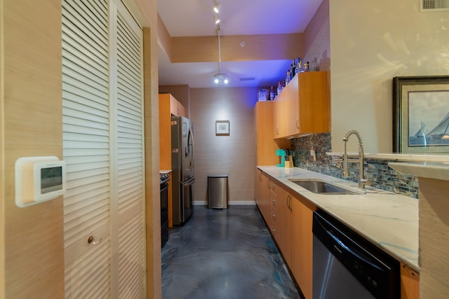 kitchen featuring light stone countertops, appliances with stainless steel finishes, backsplash, and sink