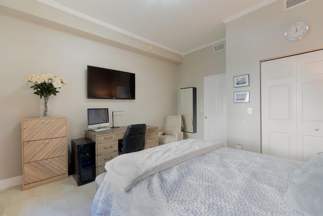 bedroom featuring a closet, light tile patterned floors, and ornamental molding