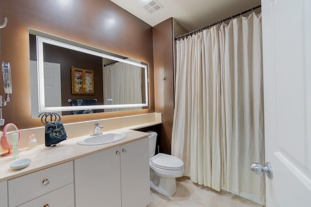 bathroom featuring tile patterned flooring, vanity, and toilet