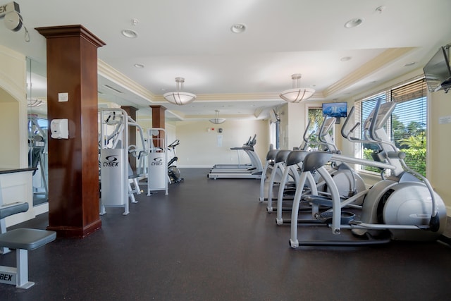 gym with a raised ceiling and crown molding